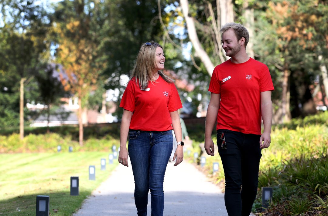 photograph of two volunteers walking along the path in the garden at Strawberry Field