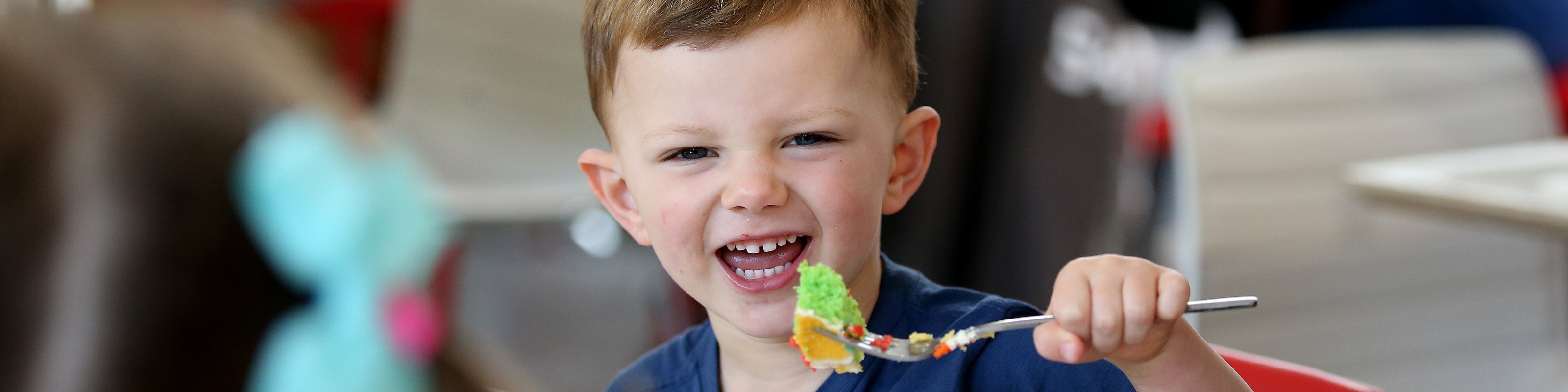 Little boy enjoying cake in the Imagine More café